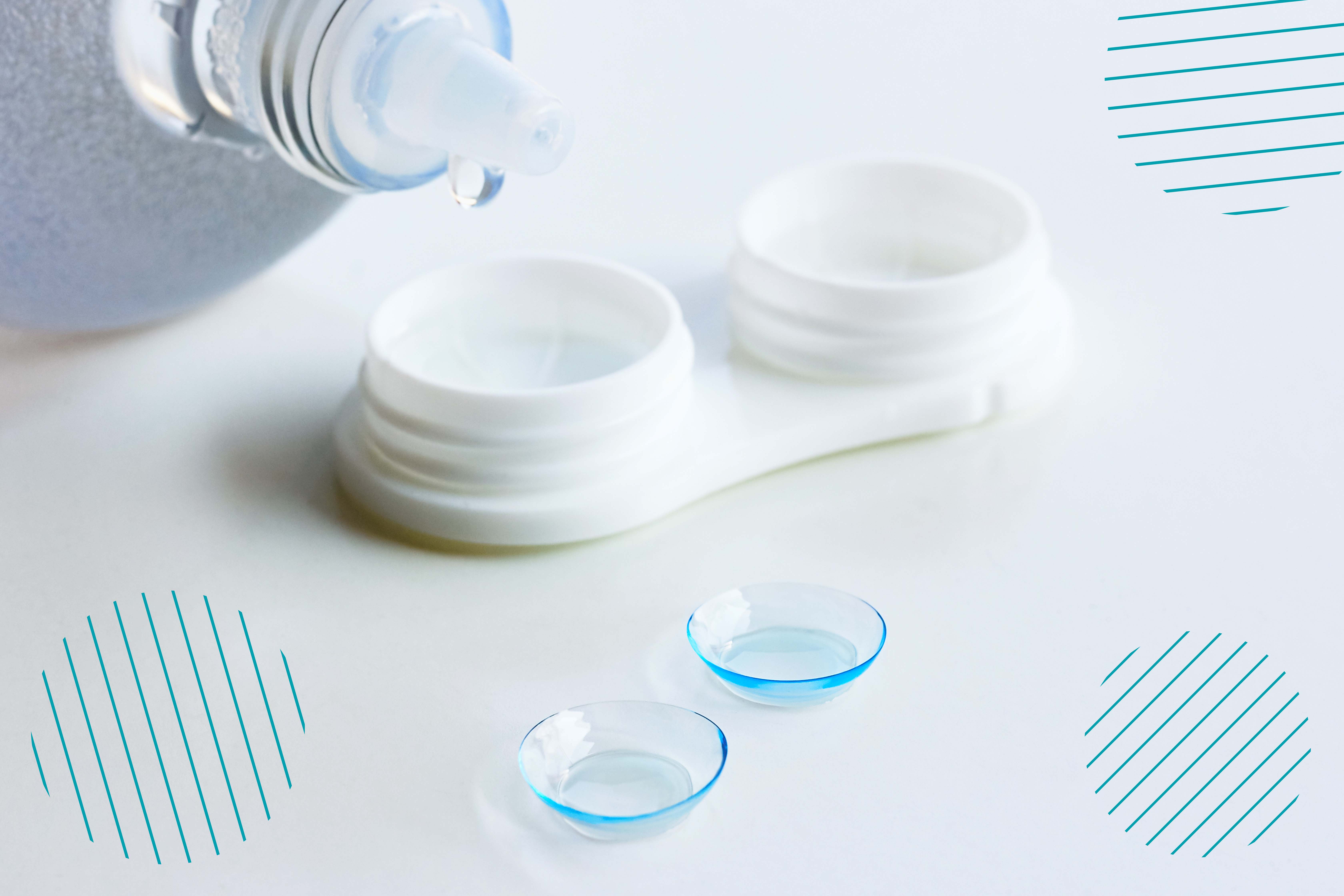 Dos lentes de contacto se encuentran colocados en una superficie, mientras se está a punto de agregar líquido desinfectante al estuche para conservarlos
